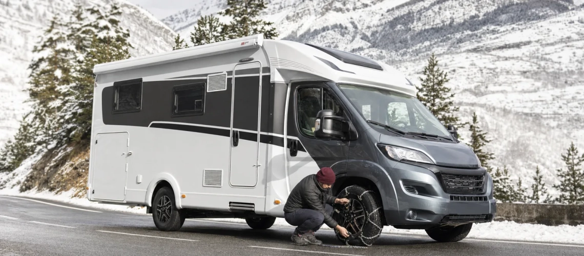 Camper preparada con cadenas en una carretera nevada del Pirineo francés