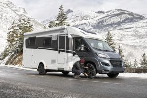 Camper preparada con cadenas en una carretera nevada del Pirineo francés